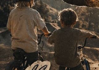 Two kids on bikes at the dirt track